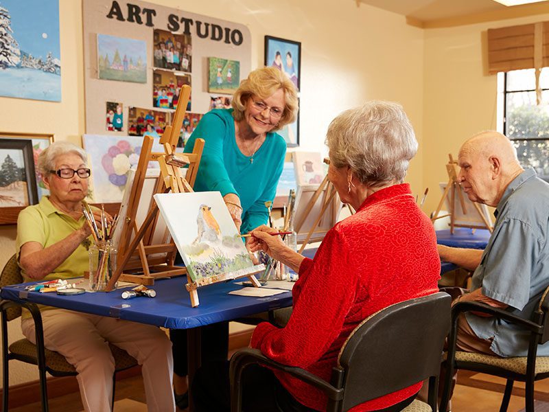 Seniors enjoying a painting session in the art studio of Cypress Court